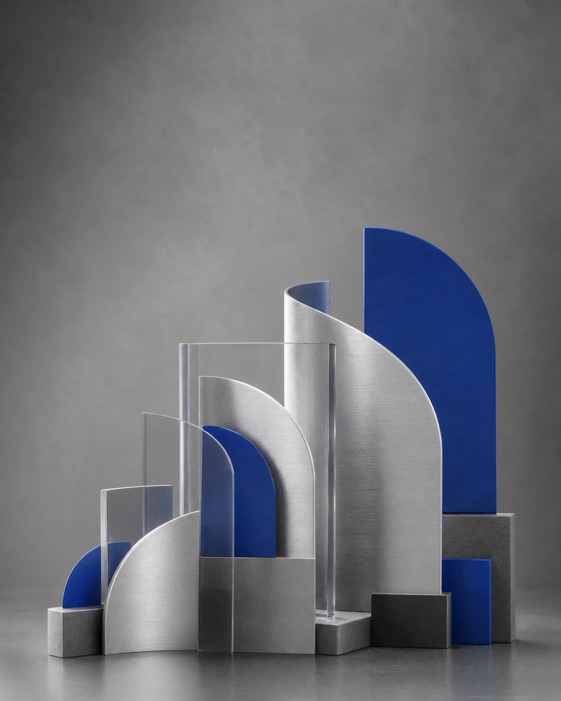 Abstract arrangement of cobalt and brushed metal forms in a clear sequence